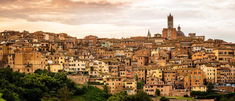Panorama del borgo di Pitigliano al tramonto, con le sue costruzioni in tufo illuminate da una luce dorata.