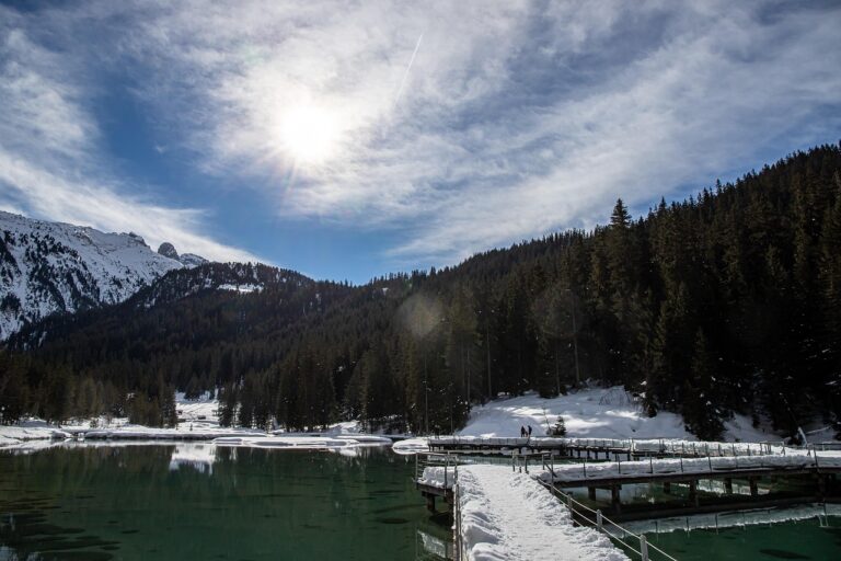 Lago turchese circondato da montagne delle Dolomiti, tranquillità e bellezza naturale.